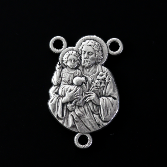 Saint Joseph rosary centerpiece that depicts Saint Joseph holding child Jesus in one arm and a lily in the other. 
