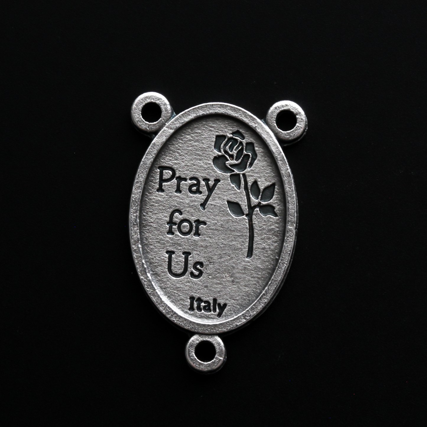 Saint Joseph rosary centerpiece that depicts Joseph holding child Jesus in one arm and a lily in the other
