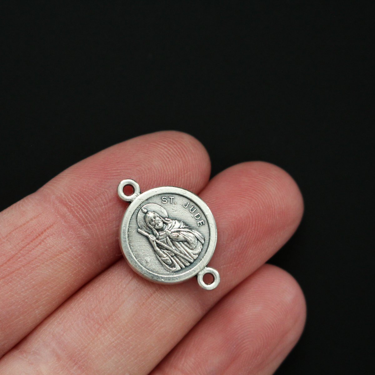 Saint Jude round flat connector links that are silver oxidized plating on a base metal