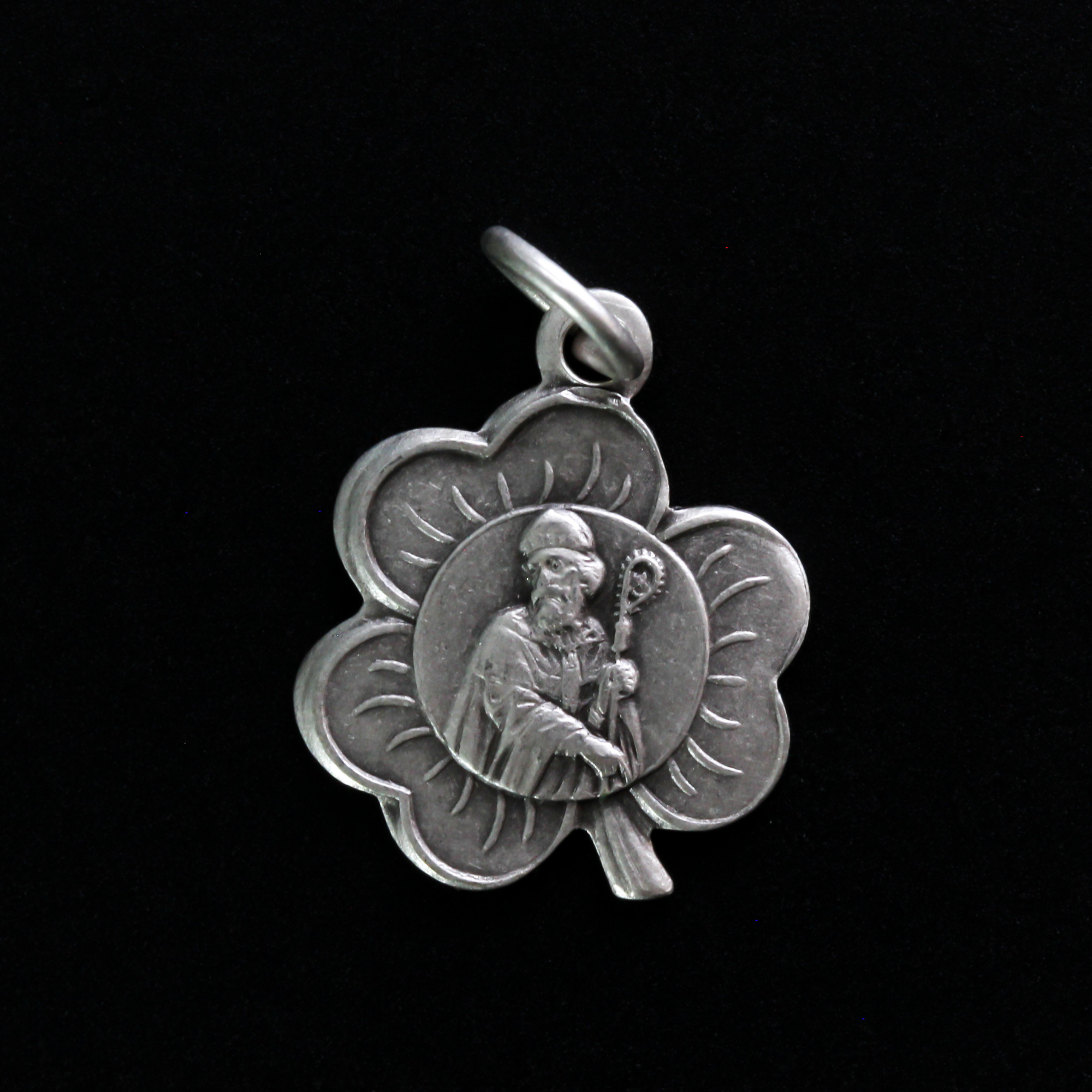 Small silver-tone St. Patrick shamrock-shaped charm. The front depicts Saint Patrick and the reverse is marked "Saint Patrick"