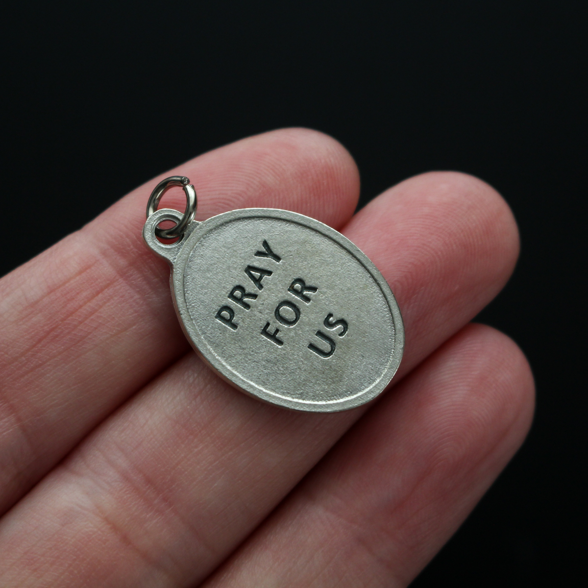 Saint Robert Bellarmine medal that depicts the saint on the front and is marked "Pray For Us" on the back.