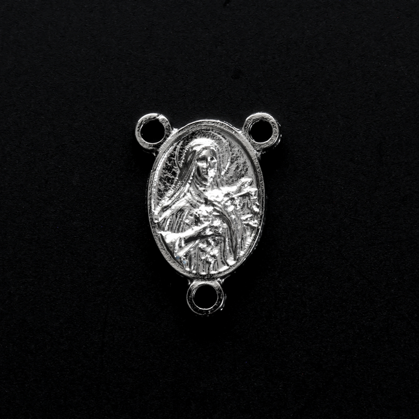 Silver-tone Saint Therese of Lisieux rosary centerpiece. There is a third-class relic from the soil beneath her coffin on the backside of the centerpiece.