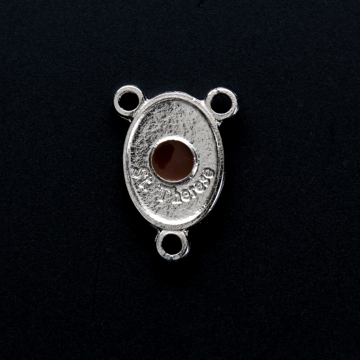 Silver-tone Saint Therese of Lisieux rosary centerpiece. There is a third-class relic from the soil beneath her coffin on the backside of the centerpiece.
