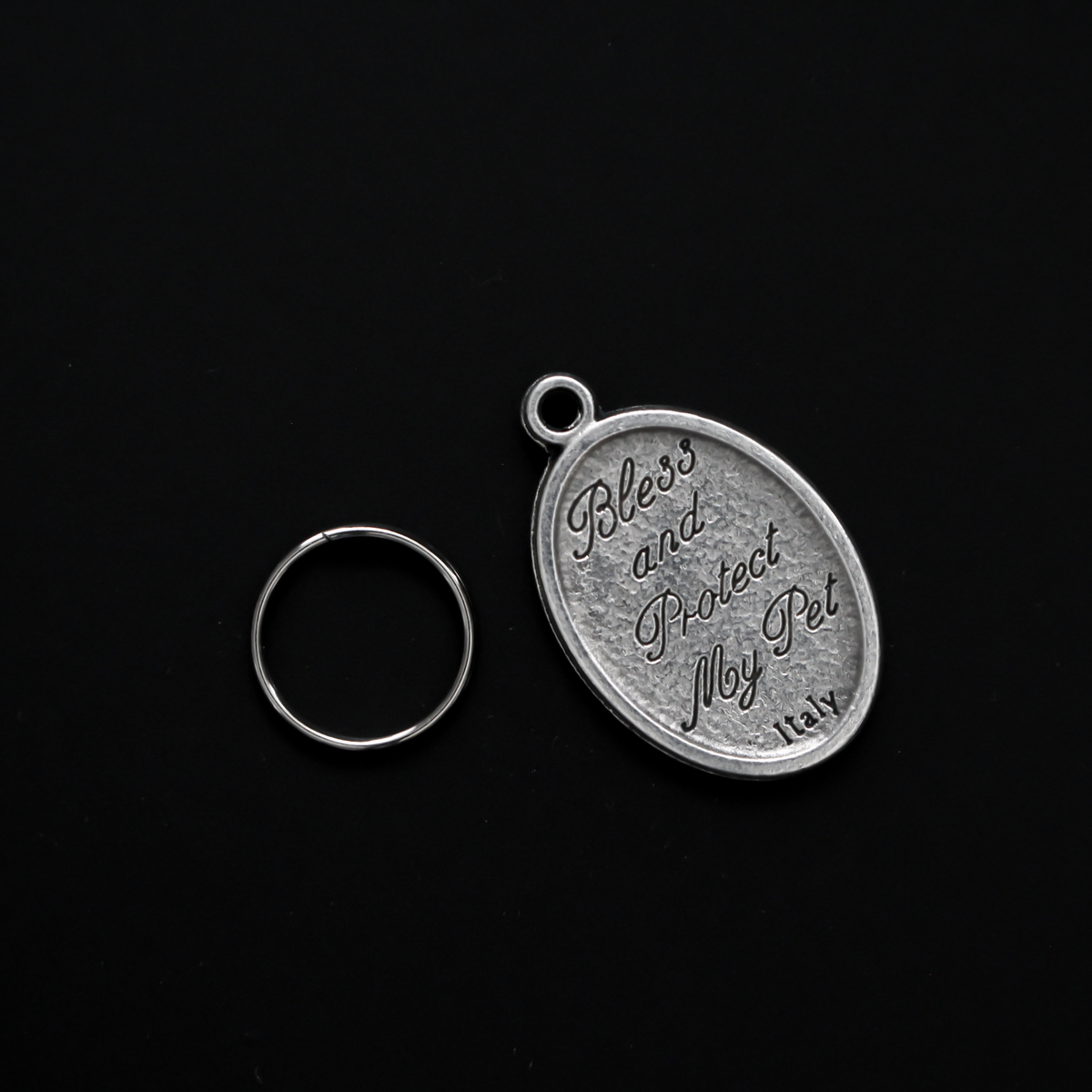 Saint Francis medal that depicts the saint with a wolf on the front. The reverse is marked "Bless and Protect My Pet" in cursive writing