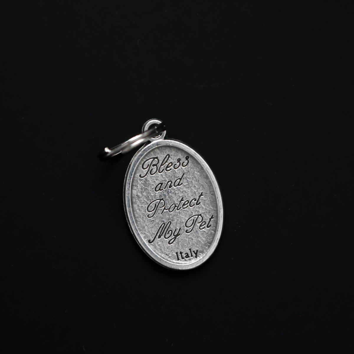 Saint Francis medal that depicts the saint with a wolf on the front. The reverse is marked "Bless and Protect My Pet" in cursive writing