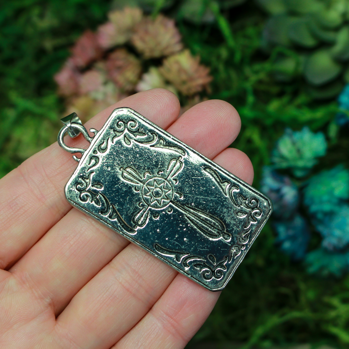 Large tarot card pendant depicting the "Wheel of Fortune" card. There is a jump ring attached to the bail.