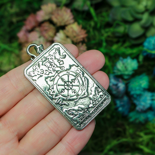 Large tarot card pendant depicting the "Wheel of Fortune" card. There is a jump ring attached to the bail.