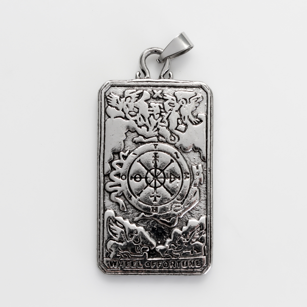 Large tarot card pendant depicting the "Wheel of Fortune" card. There is a jump ring attached to the bail.