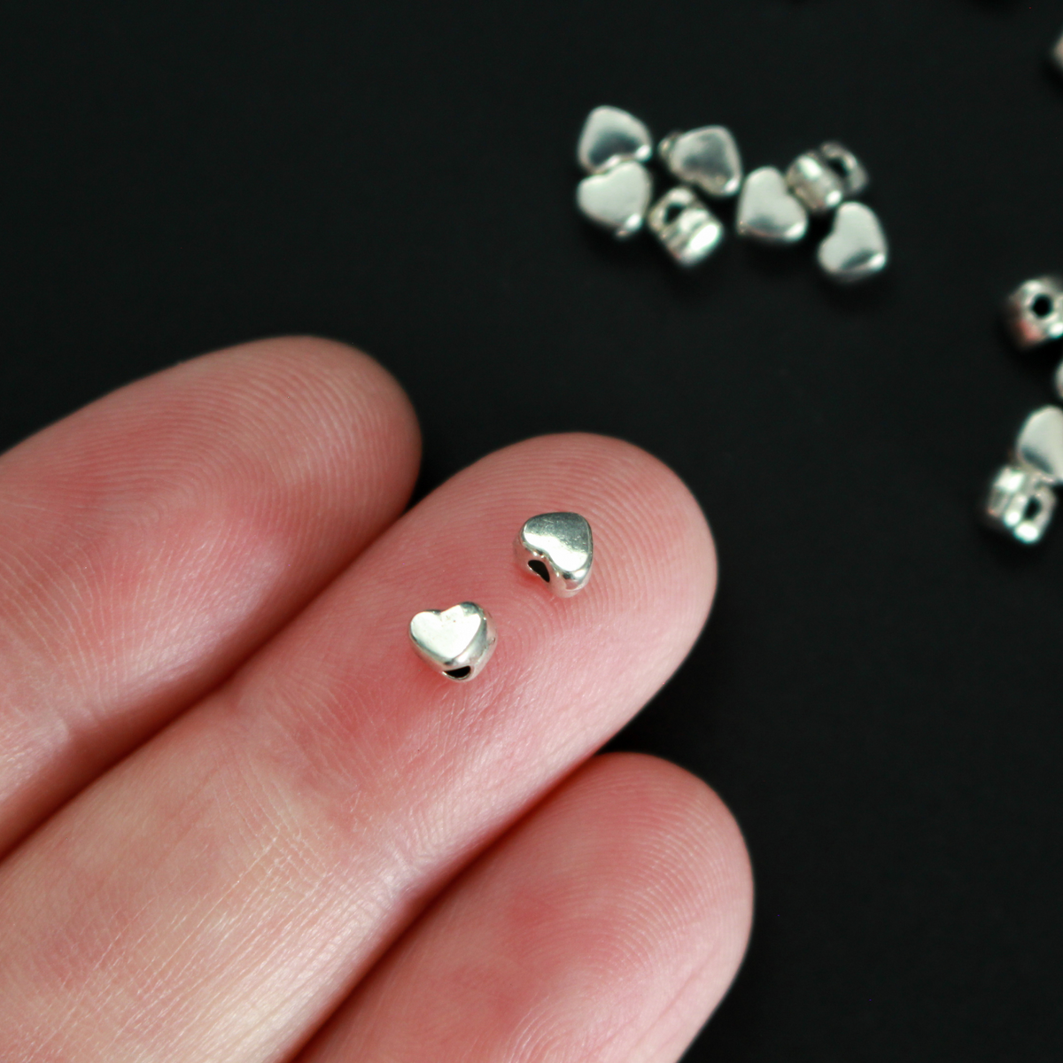 Tiny silver-tone metal beads shaped like hearts, 4mm wide