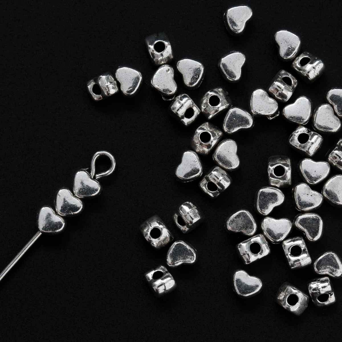 Tiny silver-tone metal beads shaped like hearts, 4mm wide