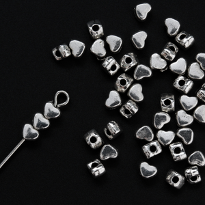 Tiny silver-tone metal beads shaped like hearts, 4mm wide
