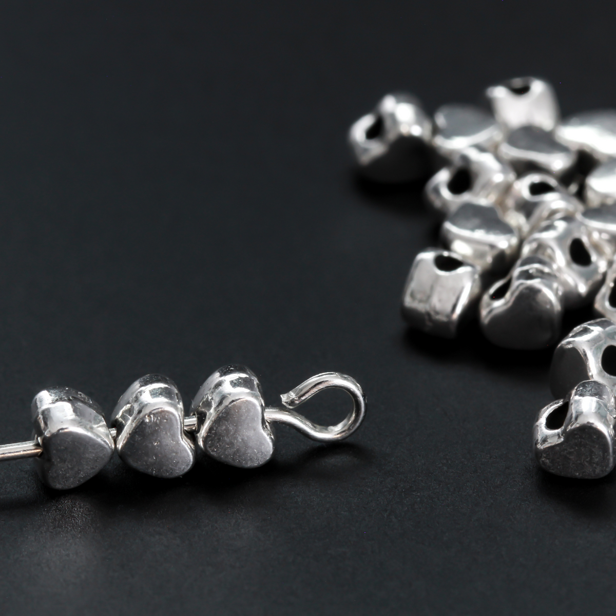 Tiny silver-tone metal beads shaped like hearts, 4mm wide