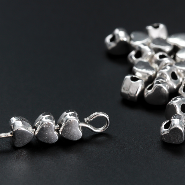 Tiny silver-tone metal beads shaped like hearts, 4mm wide