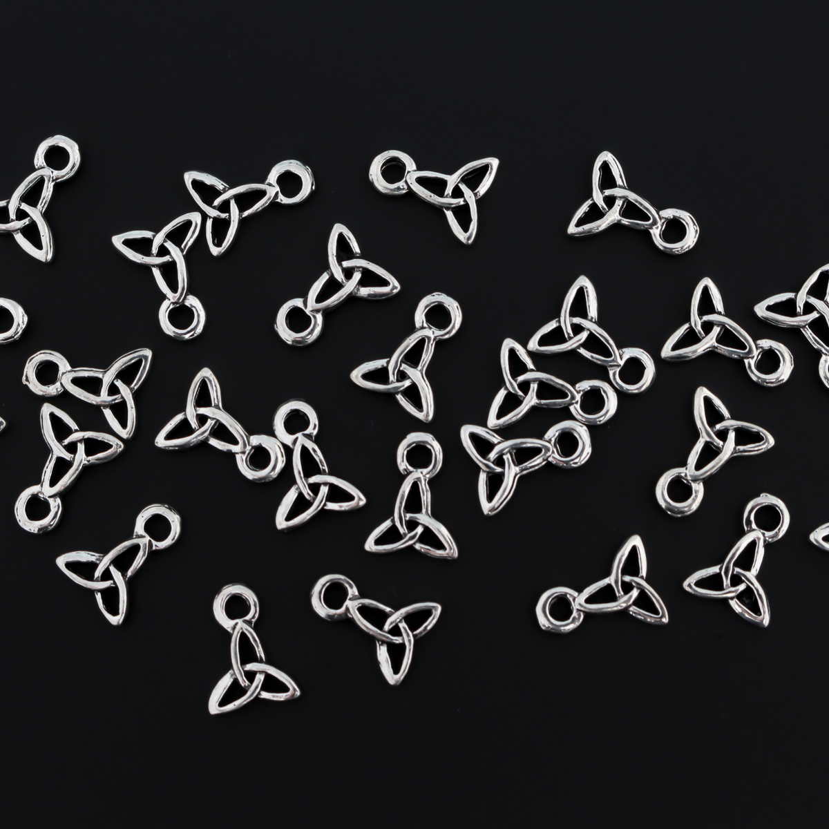 Celtic trinity knot charms that are an antiqued silver tone color. The trinity knot is a symbol of the the holy trinity