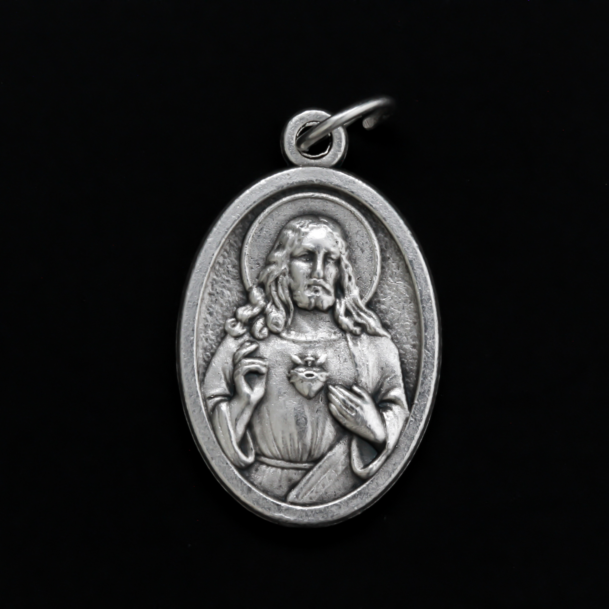 One inch oval medal that features an image of The Immaculate Heart of Mary on the front with an image of The Sacred Heart of Jesus on the back